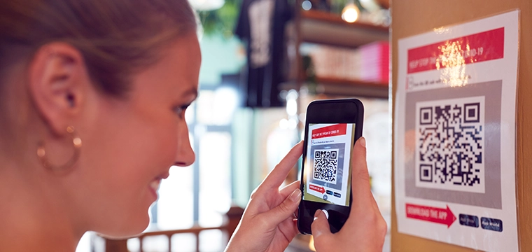 Woman reading a QR code with phone