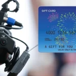 Video camera with Visa Gift Card in foreground