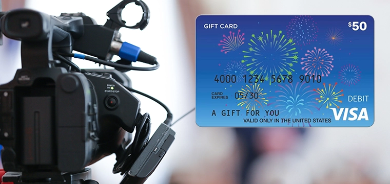 Video camera with Visa Gift Card in foreground