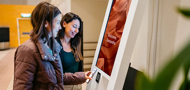 women at kiosk with mobile phone