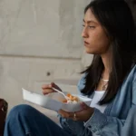 Student looking sad eating lunch