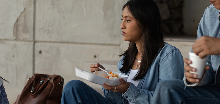 Student looking sad eating lunch