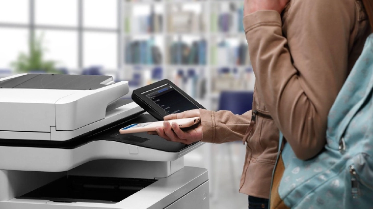 woman at printer with phone