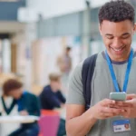 Student with phone and ID card